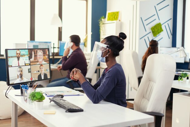 Emprendedor africano con una videoconferencia durante covid19 con mascarilla