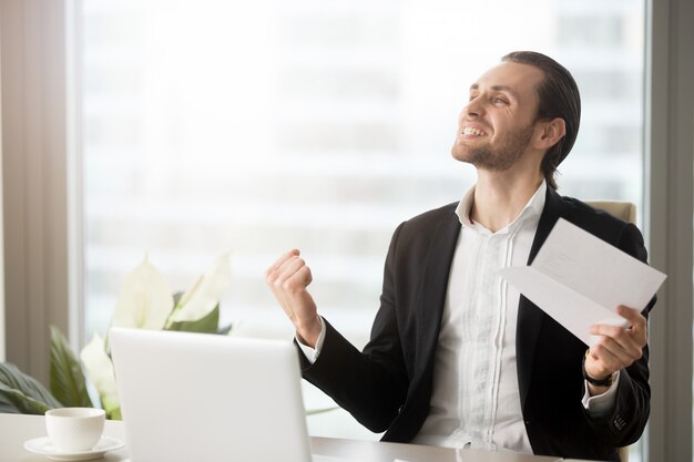 Emprendedor emocionado con logros en el trabajo.