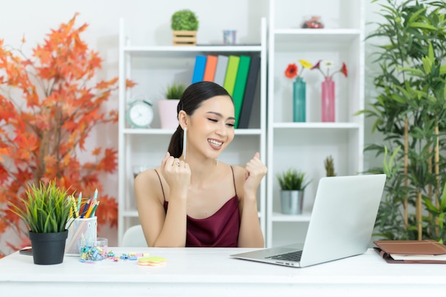 La empresaria asiática toma un descanso para tomar café después de trabajar en la computadora de computadora portátil en el escritorio