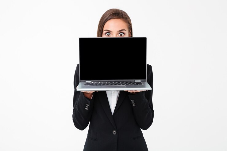 Foto gratuito empresaria bonita sorprendida que muestra la pantalla de la computadora portátil