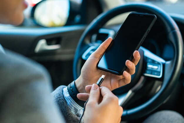 La empresaria cargando su teléfono en el coche