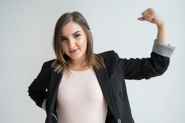 Empresaria caucásica joven feliz que muestra la muestra del éxito