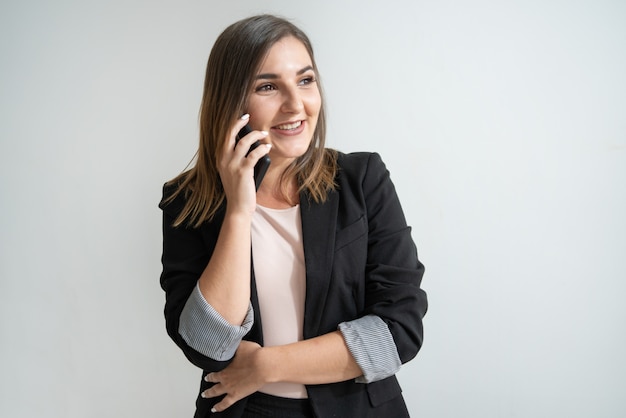 Foto gratuita empresaria caucásica joven positiva que habla en el teléfono