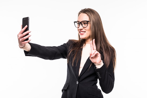 La empresaria en la clásica suite negra sobre blanco tiene una videollamada en su teléfono