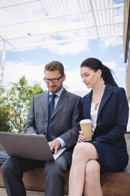 Empresaria y colega usando laptop