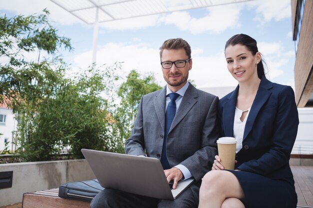 Empresaria y colega usando laptop