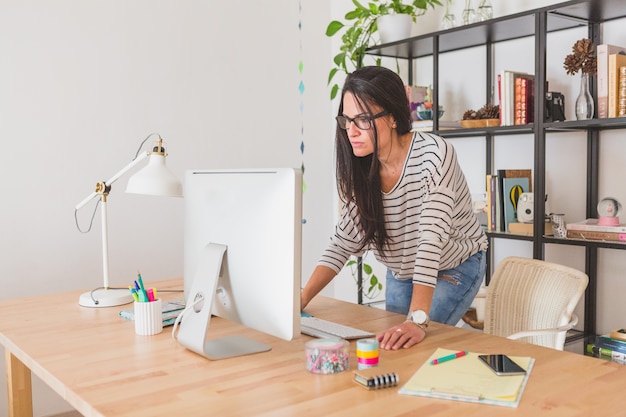 Foto gratuita empresaria concentrada trabajando con el ordenador en la oficina