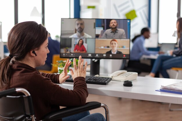 Empresaria discapacitada en silla de ruedas con conferencia de reunión de videollamada en línea