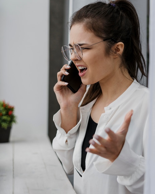 Foto gratuita empresaria enojada con una mala llamada