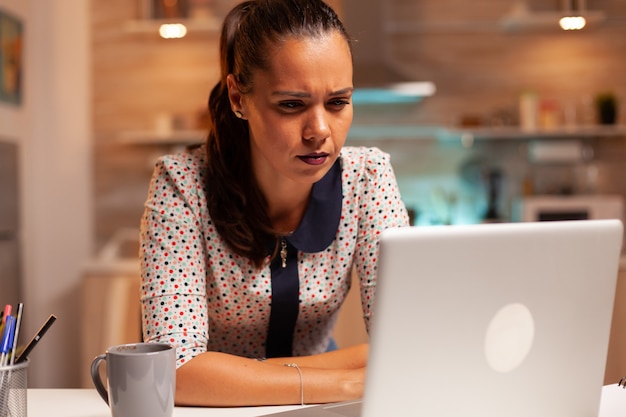 Empresaria entrecerrando los ojos debido al agotamiento mientras trabaja en un proyecto a altas horas de la noche desde casa. Empleado utilizando tecnología moderna a medianoche haciendo horas extraordinarias para trabajo, negocios, carrera, red, li