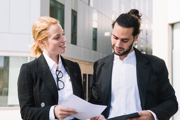 Empresaria feliz que muestra el documento al hombre de negocios