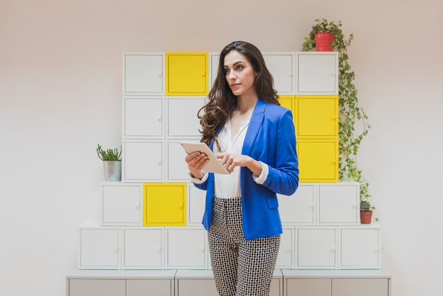 Empresaria guapa con chaqueta azul y tableta