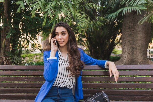 Empresaria hablando por teléfono y descansando en el parque