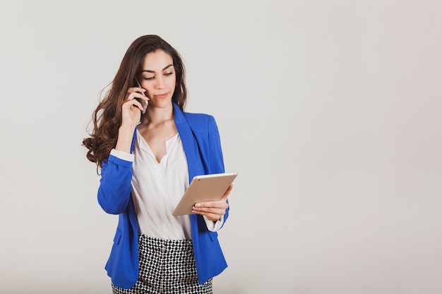 Foto gratuita empresaria hablando por teléfono mientras sujeta una tableta