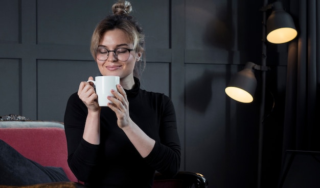 Foto gratuita empresaria inteligente tomando una taza de café