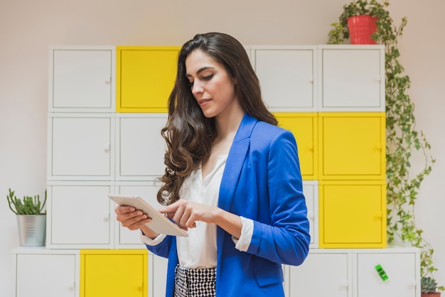 Foto gratuita empresaria joven concentrada trabajando con su tableta