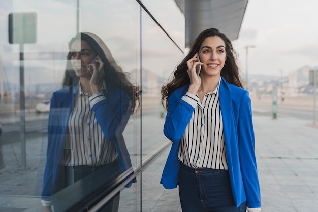 Empresaria joven elegante hablando por teléfono