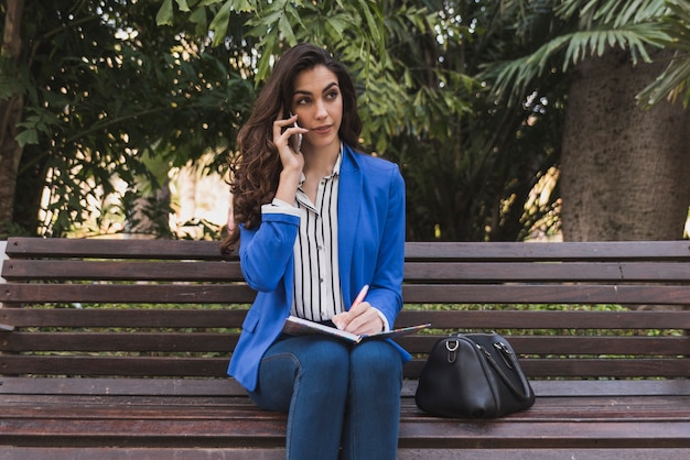 Foto gratuita empresaria joven pensando mientras habla por teléfono