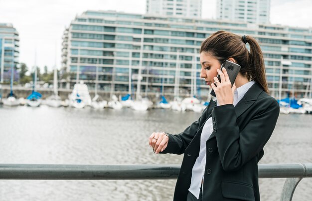 Empresaria joven que se coloca cerca del puerto que controla el tiempo