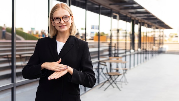 Foto gratuita la empresaria mediante lenguaje de señas al aire libre en el trabajo