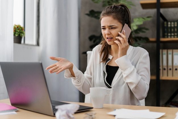 Foto gratuita empresaria con una mala llamada del trabajo