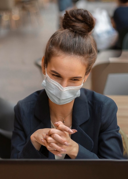 Empresaria con máscara médica con una videollamada