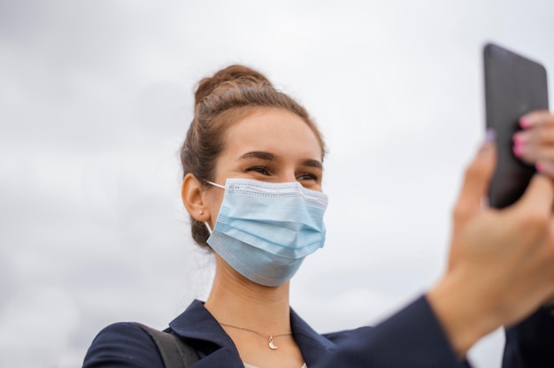 Foto gratuita empresaria con mascarilla tomando una foto