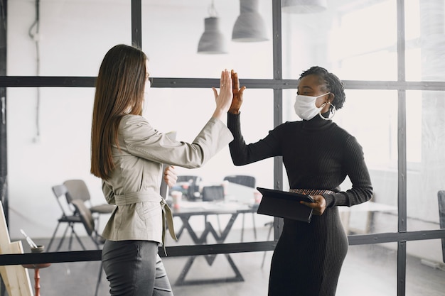 Empresaria con mascarilla trabajando con papeles. Empresa exitosa, trabajo en equipo.