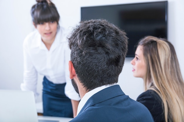 Foto gratuita empresaria mirando a los empresarios en la reunión