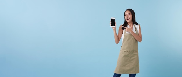 Empresaria mujer asiática mostrando y señalando con la mano el dedo al teléfono inteligente de pantalla en blanco