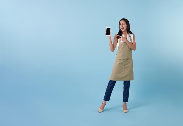 Empresaria mujer asiática mostrando y señalando con la mano el dedo al teléfono inteligente de pantalla en blanco