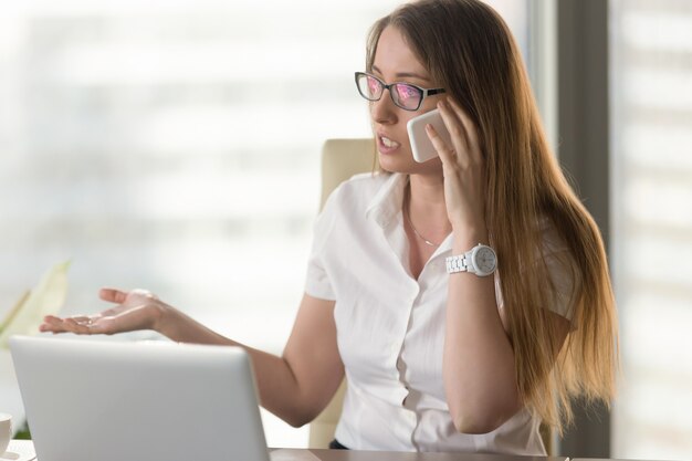 Empresaria ocupada discutiendo por teléfono