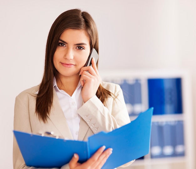 Foto gratuita empresaria ocupada hablando por teléfono inteligente