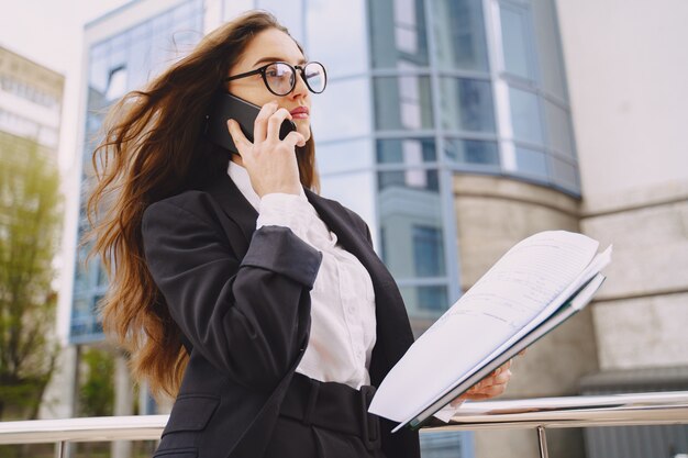 Empresaria de pie al aire libre en el edificio de oficinas de la ciudad