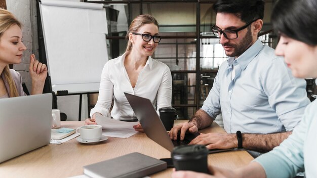 Empresaria profesional con gafas durante una reunión con sus compañeros