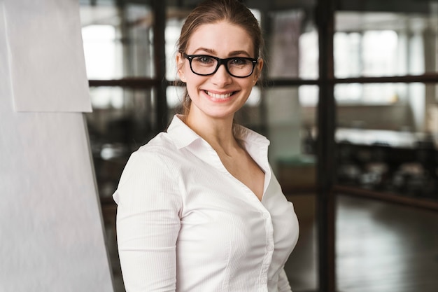 Empresaria profesional sonriente con gafas durante una presentación