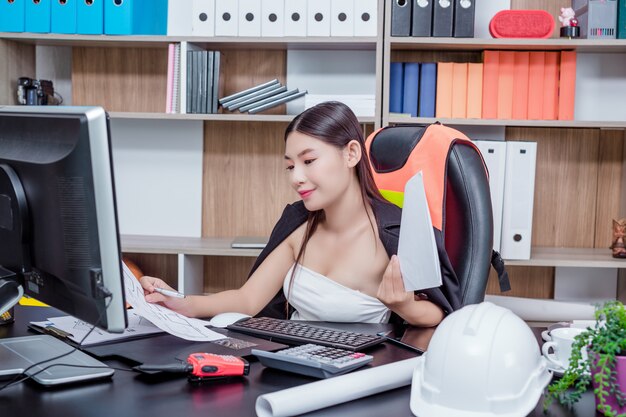 Empresaria que trabaja en la oficina con una sonrisa mientras está sentado.