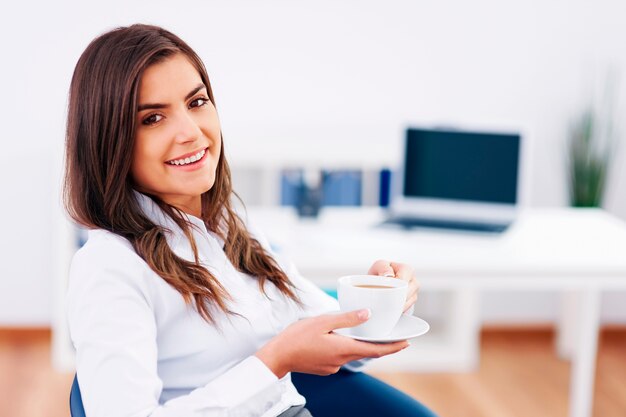 Empresaria relajada teniendo un descanso y tomando café