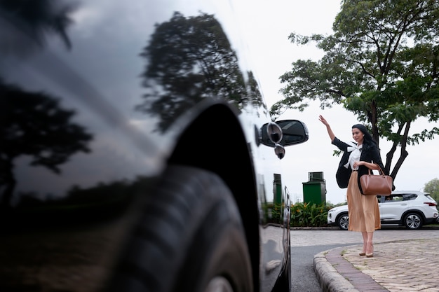 Foto gratuita la empresaria saludando a su taxi