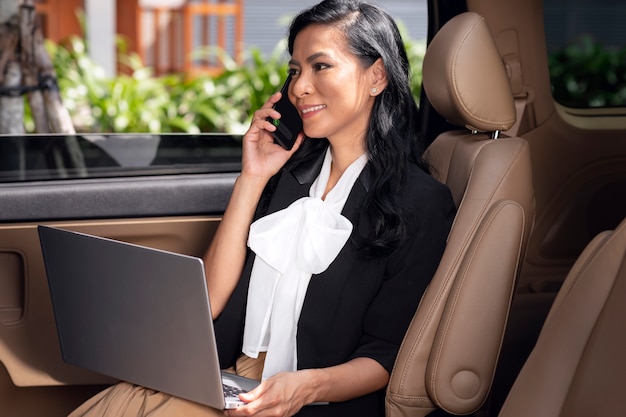 La empresaria sentada en el asiento trasero de un taxi