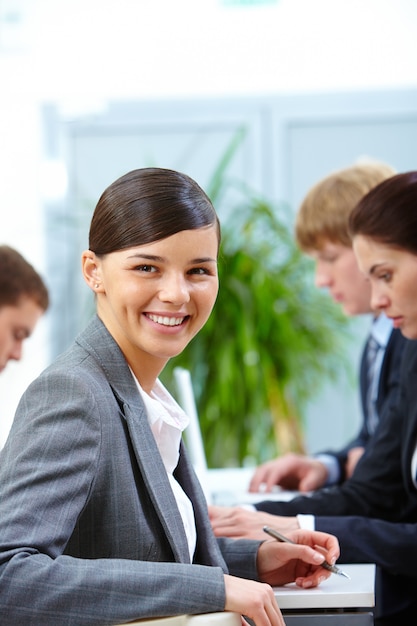 Empresaria sentada y sonriendo en el trabajo