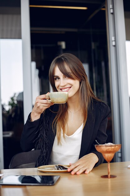 Empresaria sentado a la mesa en un café y trabajando