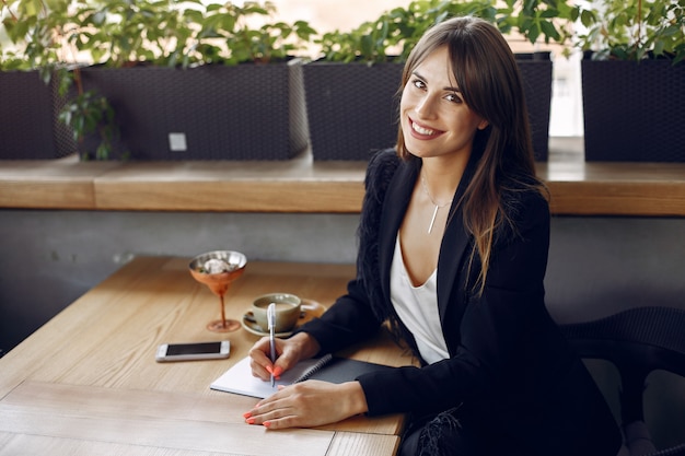 Foto gratuita empresaria sentado a la mesa en un café y trabajando