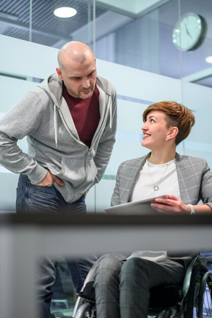 Empresaria en silla de ruedas hablando con un hombre