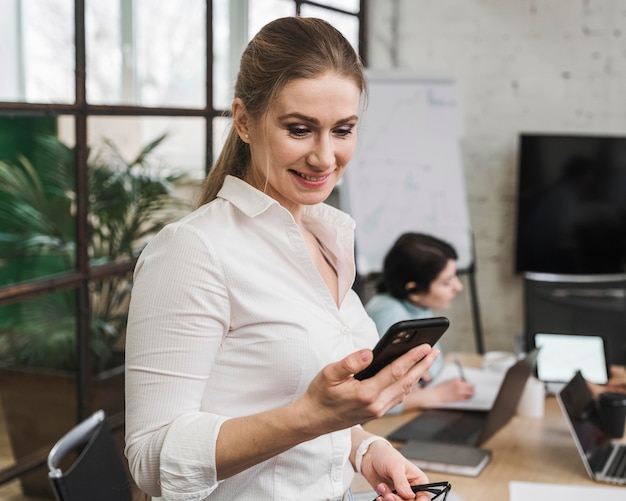 La empresaria con smartphone durante una reunión