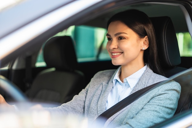 Empresaria sonriente conduciendo su coche en la ciudad