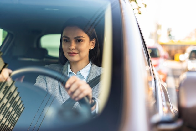 Empresaria sonriente conduciendo su coche