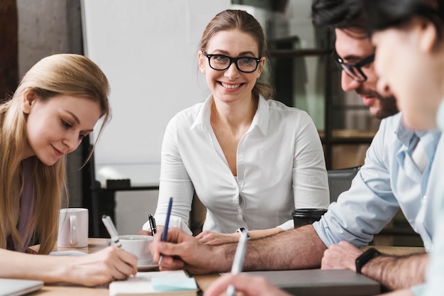 Empresaria sonriente con gafas durante una reunión