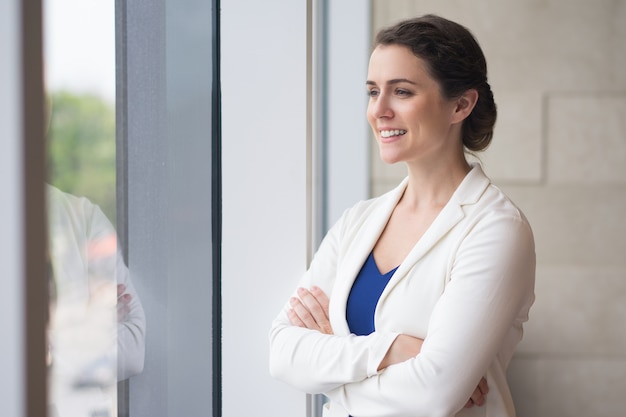 Foto gratuita empresaria sonriente mirar por la ventana