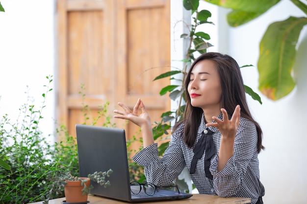 La empresaria sonriente muestra gestos para meditar